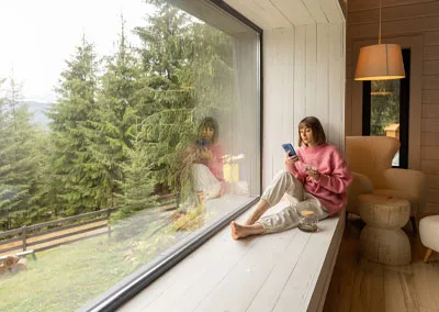 A cozy reading nook featuring a large operable awning window with a view of the West Kootenay landscape in nelson bc.